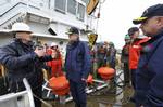 PORTLAND, Maine- Mike Popovich (LEFT), an environmental equipment specialist from the First Coast Guard District in Boston, explains how the vessel of opportunity skimming system will work when it is deployed from the Coast Guard Cutter Marcus Hanna during the Spill of National Significance Drill, March 23, 2010. This SONS exercise simulates a rare catastrophic oil spill in the Gulf of Maine, with events will taking place in Boston, Maynard, Mass., Portland, Maine, Portsmouth, New Hampshire, Was