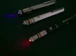 A laser pointer or laser pen (color: red, green, violet) is a small portable device with a power source (usually a battery) and a laser emitting a very narrow coherent low-powered beam of visible light, intended to be used to highlight something of interest by illuminating it with a small bright spot of colored light.