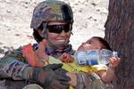 U.S. Army Spc. Samantha Hall, attached to A Battery, 2nd Battalion, 377th Parachute Field Artillery Regiment, Task Force 4-25, holds a local child during a rest break while patrolling Loy Murghoz for weapon caches in Khowst province, Afghanistan, June 8, 2012.