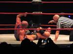 Styles performing a figure-four leglock on Kurt Angle.