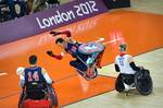 U.S. Navy retired William Groulx, U.S. Wheelchair Rugby Captain, falls after a member of the Great Britain team crashes into him during a match at the basketball arena during the London Paralympic Games, Sept. 5, 2012. The Paralympic Games are a major international multi-sport event where athletes with a physical disability compete; this includes athletes with mobility disabilities, amputations, blindness, and cerebral palsy. (U.S. Air Force photo by MSgt Sean M. Worrell)