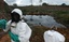 Waste removal experts work to remove hazardous black sludge from a garbage dump in Abidjan, Ivory Coast in this Sunday, Sept. 17, 2006 file photo. Ivory Coast's government put 12 people on trial Monday, Sept. 29, 2008 in connection with a toxic waste dumping scandal the government says killed at least 10 people two years ago.