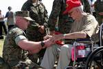 World War II veteran William Leverence autographs a book for U.S. Marine Staff Sgt. Cox on the island of Iwo Jima just before the Iwo Jima ceremony kicks off.