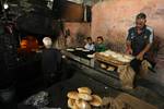 A Palestinians bake bread at a traditional bakery in the Palestinian Rafah refugee camp, in the southern Gaza Strip on September 24, 2012. 