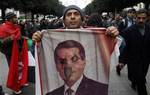 A protestor holds a burn picture of former Tunisian President Zine El Abidine Ben Ali during a demonstration in Tunis, Tuesday, Jan. 25. 2011. Hundreds of Tunisian protesters are demonstrating outside the prime minister's office to demand the removal of members of the ousted president's regime still in the government.