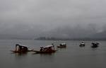 Tourists enjoy shikara ride at World Famous Dal Lake during a rain in Srinagar on Sunday 09, September 2012. Incessant rains continued to lash Kashmir since Saturday night, sparking crop damage fears among the farming community of the Valley.