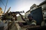 SOMALIA, Mogadishu: In a photograph released by the African Union-United Nations Information Support Team 06 August 2012, a Burundian soldier serving with African Union Mission in Somalia (AMISOM) provides top-cover on an armed personnel carrier as an AMISOM convoy makes it way through the Somali capital Mogadishu. August 06 is the one-year anniversary marking the date that Al-Qaeda-affiliated extremist group Al Shabaab withdrew from fixed positions in Mogadishu after having steadily lost territ