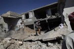 Syrians clear the rubble of a house which was destroyed in a government airstrike on Saturday, in Kal Jubrin, on the outskirts of Aleppo, Syria, Sunday, Sept. 16, 2012.