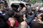 Plainclothes policemen push members of the outlawed Muslim Brotherhood into a police car