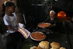 A Palestinians bake bread at a traditional bakery in the Palestinian Rafah refugee camp, in the southern Gaza Strip on September 24, 2012. 