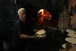 A Palestinians bake bread at a traditional bakery in the Palestinian Rafah refugee camp, in the southern Gaza Strip on September 24, 2012. 