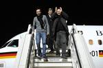 Journalists Jens Koch, left, and Marcus Hellwig, right, are accompanied by German Foreign Minister Guido Westerwelle as they arrive at Tegel airport in Berlin Sunday morning, Feb. 20, 2011. Iran freed the two German journalists arrested four months ago in connection with a highly publicized stoning case, and Germany's foreign minister went to Tehran on Saturday to bring the reporters home in a rare top-level visit by a Western government representative.