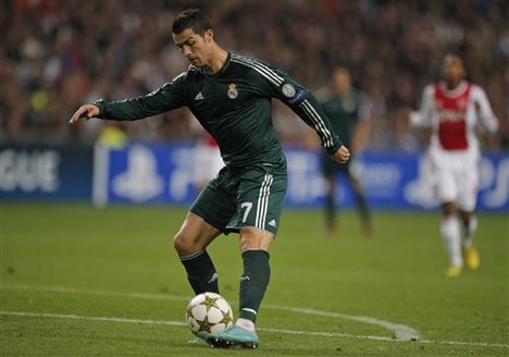 Real Madrid player Cristiano Ronaldo tips the ball over Ajax goalkeeper Kenneth Vermeer, not seen, to score 4-1 during the Champions League Group D soccer match at ArenA stadium in Amsterdam, Netherlands, Wednesday Oct. 3, 2012.