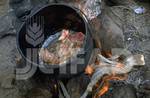 Llama meat being cooked over an open fire. Juana Guarache, a Bolivian agronomist, points out that “llama meat is gaining more of a market, Bolivia.