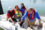 MARLBOROUGH POINT, VA (April 21, 2007) U.S. Power Squadron member, Curt Johnson (left) and Boat/US President and U.S. Coast Guard Auxiliary Honorary Commodore, Richard Schwartz, jointly affix a special 60th Anniversary Vessel Safety Check decal on a boat owned by Commodore Schwartz after U.S. Coast Guard Auxiliary and U.S. Power Squadron Vessel Examiners conducted a Vessel Safety Check aboard the vessel and found everything shipshape. Hannah Newburger, 11; Adam Newburger, 9 (second and third fro