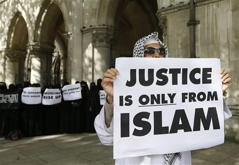 Demonstrators gather outside The Royal Courts of Justice in London Friday, Oct. 5, 2012. Radical Islamist preacher Abu Hamza and four other terror suspects are being extradited to the United States.