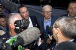 Chairman of News Corporation Rupert Murdoch, center right, and his son James Murdoch, center left, chief executive of News Corporation Europe and Asia face the media as they arrive at his residence in central London, Sunday, July 10, 2011. News of the World cease publication with Sunday issue the last. News of the World is accused of hacking into the mobile phones of various crime victims, celebrities and politicians.