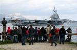 People wave to relatives aboard the French nuclear-powered aircraft carrier Charles de Gaulle at Toulon military harbor, southern France, Sunday, March 20, 2011, as he leaves its home to off Lybian coasts. Top officials from the United States, Europe and the Arab world have launched immediate military action to protect civilians as Libyan leader Moammar Gadhafi's forces attacked the heart of the country's rebel uprising .