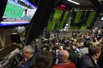 Traders are seen working in the S&P 500 pit at the Chicago Board Options Exchange Wednesday, March 18, 2009, in Chicago, as a monitor shows Edward Liddy, chief executive of AIG