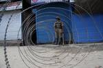 Indian paramilitary troops stand infront of razore wire during a curfew in downtown area of Srinagar, the summer capital of Indian Kashmir, 26, June, 2012. Authorities imposed curfew in old part of Srinagar city in anticipation of clashes over shrine blaze. The historical shrine of 11th century saint, Sheikh Syed Abdul Qadir Jeelani (locally called Dastgeer Sahib) gutted in devastating fire on Monday. The fire caused massive damage to two centuries old shrine. Soon after the shrine blaze clashes