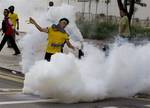 A protester throws a tear gas canister back at police in Kuala Lumpur, Malaysia, Saturday, April 28, 2012. Malaysian police fired tear gas and chemical-laced water Saturday at thousands of demonstrators demanding an overhaul in electoral policies that they call biased ahead of national polls expected soon.At least 25,000 demonstrators had swamped Malaysia's largest city in one of the Southeast Asian nation's biggest street rallies in the past decade. (AP Photo/Mark Baker)