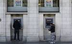 This Nov. 25, 2010 file photo shows people withdrawing money from a branch of Allied Irish Bank in Central Dublin, Ireland. The Irish government is preparing to take majority control of a fourth bank, Allied Irish Banks, as it struggles to fix the nation's ravaged banking sector, according to news reports Thursday Dec. 23, 2010. The Irish Times and broadcaster RTE said Finance Minister Brian Lenihan will go to court to seek permission to pump another euro3.7 billion ($4.85 billion) from the Nati