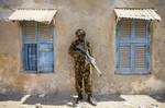 SOMALIA, Kismayo: In a handout photograph taken 05 October and released by the African Union-United Nations Information Support Team 06 October, a soldier of the Kenyan Contingent serving with the African Union Mission in Somalia (AMISOM) stands guard on a street in the centre of the southern Somali port city of Kismayo adjacent to the old police station while a combat engineering team inspects the surrounding area following reports of a suspected improvised explosive device (IED) left behind by