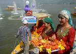 Kashmiri girls wearing traditional attire welcome tourists during the Shikara (boat) Festival in Srinagar October 2, 2012. According to the festival's organisers, who come from Kashmir's tourism department, the festival was organised for foreign tour agents that are currently touring Kashmir to promote the country's tourism and to attract foreign tourists to Kashmir.