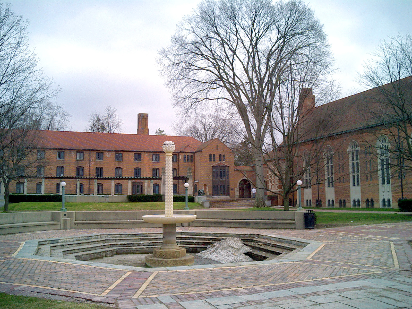 Several three-story brick buildings surrounding a large courtyard with fountain