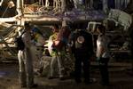 An Israeli religious Zaka rescue and recovery personal holds a Torah scroll from a synagogue in a damaged building , Friday, June 17, 2011 in Netanya, Israel. Police say a large explosion has rocked the coastal Israeli