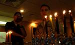 Machinist's Mate 3rd Class Jesse Kopelman and Nimitz-class aircraft carrier USS Harry S. Truman (CVN 75), Commanding Officer, Capt. Herman Shelanski sings from the Torah during a Chanukah celebration.