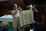 Cmdr. Joel Newman, left, a Rabbi aboard the Nimitz-class aircraft carrier USS Ronald Reagan (CVN 76), unrolls a Torah in the ships chapel during an introduction class to the Jewish religious holiday of Yom Kippur before a brief Yom Kippur service.