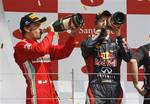 Spain's Ferrari Formula 1 driver Fernando Alonso, left, who finished second at the Formula One British Grand Prix, and Germany's Red Bull Formula 1 driver Sebastian Vettel, right, who finished third, drink champagne as they celebrate at the Silverstone circuit, Silverstone, England, Sunday, July 8, 2012. Australia's Red Bull Formula 1 driver Mark Webber, won the race.