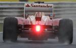 Spain's Ferrari driver Fernando Alonso steers his car through the rain during the second training session at the Hungaroring circuit outside Budapest, Hungary