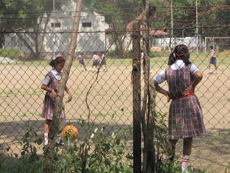 School children - girls and boys playing on the school ground in the school - India