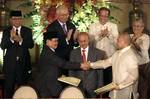 Government peace negotiator Marvic Leonen, right, and Moro Islamic Liberation Front chief negotiator Mohagher Iqbal, left, shake hands as they exchange signed peace documents following formal signing ceremony Monday Oct. 15, 2012 at Malacanang Palace in Manila, Philippines. Witnessing the signing are Malaysian peace broker Dato Tengko Abdul Ghafar, center, and from left second row, MILF Chair Al Haj Murad, Malaysian Prime Minister Najib Razak, Philippine President Benigno Aquino III, and Governm