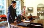 President George W. Bush signs The Flight 93 National Memorial Act in the Oval Office Tuesday, Sept. 24. The bill authorizes the building of a national memorial to the passengers and crew who died aboard Flight 93 when it crashed into Shanksville, Pa., during the Sept. 11 terrorist attacks. Standing with the President are Pennsylvania Congressman Sen. Rick Santorum, far left; Rep. John Murtha, center; and Sen. Arlen Specter. Date 24 September 2002