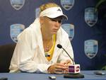 Caroline Wozniacki, of Denmark, speaks with reporters after retiring from her semifinal match, after losing the first set 7-5, against Maria Kirilenko, of Russia, at the New Haven Open tennis tournament in New Haven, Conn.