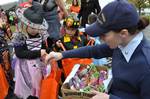 ALAMEDA, Calif. - Coast Guard Petty Officer 3rd Class Melissa Leake, a public affairs specialist stationed at Coast Guard Island, hands out candy to trick-or-treaters from the Coast Guard Island Day Care Center Oct. 29, 2010. The CDC holds a trick-or-treat parade every year. U.S. Coast Guard Photo by Petty Officer 2nd Class Sondra-Kay Kneen. (1038300) ( )