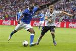 Italy's Mario Balotelli, left, kicks the ball past Germany's Holger Badstuber during the Euro 2012 soccer championship semifinal match between Germany and Italy in Warsaw, Poland, Thursday, June 28, 2012.