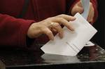 A woman casts her vote in the Irish Presidential election at a polling station in North Dublin, Ireland, Thursday, Oct. 27, 2011. Voters are picking Ireland's next president Thursday from a crowded field of seven candidates, among them a reality TV star, a former Irish Republican Army warlord and the country's top gay-rights crusader. About 3.2 million Irish citizens are eligible to vote for a successor to President Mary McAleese, Ireland's popular head of state for the past 14 years. (AP Photo/