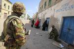 SOMALIA, Kismayo: In a handout photograph taken 05 October and released by the African Union-United Nations Information Support Team 06 October, soldiers of the Kenyan Contingent serving with the African Union Mission in Somalia (AMISOM) stand guard on a street in the centre of the southern Somali port city of Kismayo adjacent to the old police station while a combat engineering team inspects the surrounding area following reports of a suspected improvised explosive device (IED) left behind by t