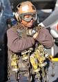 A plane captain carries tie-down chains across the flight deck of the Nimitz-class aircraft carrier USS Abraham Lincoln (CVN 72).