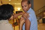 Mass Communication Specialist 1st Class Paul Cage, leading petty officer of the Naval Station Rota public affairs office, right, receives the H1N1 vaccine during base-wide immunizations.