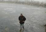 A boy walks past the frozen dal lake in srinagar on 27, Dec 2010 kashmir valley has been in the grip of cold wave with the mercury touching the mark of minus 6.2 celsius in the last week.