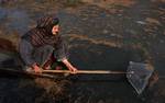 A Kashmiri boatwoman makes his way through frozen water on the Dal Lake during a cold morning in Srinagar, the summer capital of Indian Kashmir, 22 December 2010. With a steep drop in mercury, the temperature in Indian Kashmir has dropped considerably, pushing region to reel under intense cold. According to Meteorological Department officials in Srinagar Tuesday night was the season's coldest with mercury dipping to minus 5.6 degrees Celsius resulting in formation of layer of ice waterbodies.