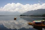 Shikaras (boats) are rowed across famous Dal Lake in Srinagar, the summer capital of Indian Kashmir, under thick clouds, on 02 June 2011. India's National Centre for Medium Range Weather Forecasting (NCMRWF) on 01 June predicted partly cloudy partly sunny weather with some temporary rains for the upcoming days with temperatures rising to up to 35 degrees Celsius (95 degrees Fahrenheit for the Srinagar region.