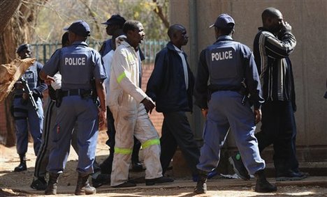 Police keep an eye on arrested mineworkers as they arrive at a court in Ga-Rankuwa, north of Pretoria, South Africa, Monday Aug 20, 2012. T