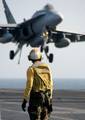 Aviation Boatswains Mate 2nd Class Reuben Nicholson, of St. Louis, Ill., watches an F/A-18C Hornet assigned to the Wildcats of Strike Fighter Squadron One Three One (VFA-131) as it comes in for an arrested landing.