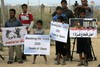 Palestinians hold slogans which read in Arabic "Oh free people, remove the blockade for us" (L) during a protest against the Egyptian decision to close the smuggling tunnels along the Gaza-Egypt border in Rafah, in the southern Gaza Strip on October 1, 2012. Since last month, Egyptian military have destroyed about 30 tunnels and blocked more which were used for smuggling to and from the Gaza Strip. The tunnels are a vital lifeline for supplies of food, clothes, building materials and fuel into the impoverished Palestinian territory subjected to an Israeli blockade since 2006.Photo by Ahmed Deeb / WN